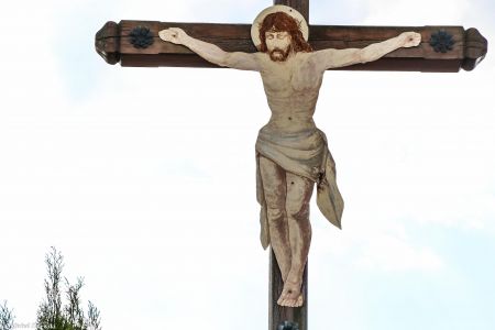 Drewniany krzyż przydrożny z malowaną na blasze figurą Chrystusa