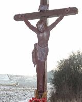 Blaszany Chrystus na przydrożnym krzyżu w Marianówce