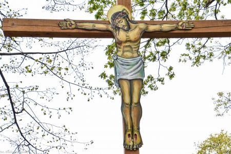 Krzyż z Chrystusem wyciętym z blachy na cmentarzu w Rudnej