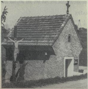 Krzyż przydrożny z blaszanym Chrystusem koło barokowej kapliczki