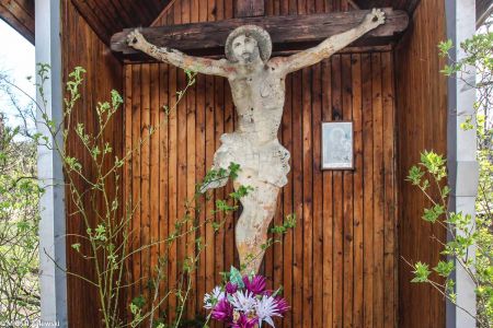 Przydrożny krzyż z malowaną na blasze sylwetkowo wyciętą postacią Chrystusa w Budzowie