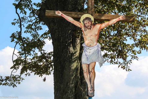 Drewniany krzyż przydrożny z Chrystusem z blachy,= w Kaczorowni pow. strzelecki