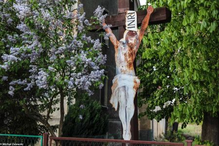 Drewniany krzyż przydrożny z Chrystusem z blachy w Tymowej