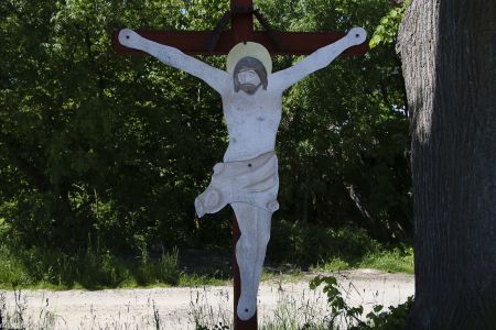 Drewniany krzyż przydrożny z blaszanym Chrystusem w Ponikwie