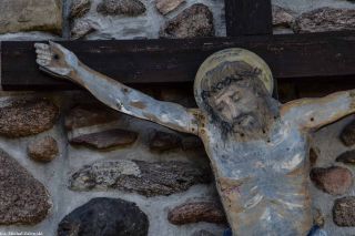 Chrystus z blachy na ścianie prezbiterium kościoła w Raculi
